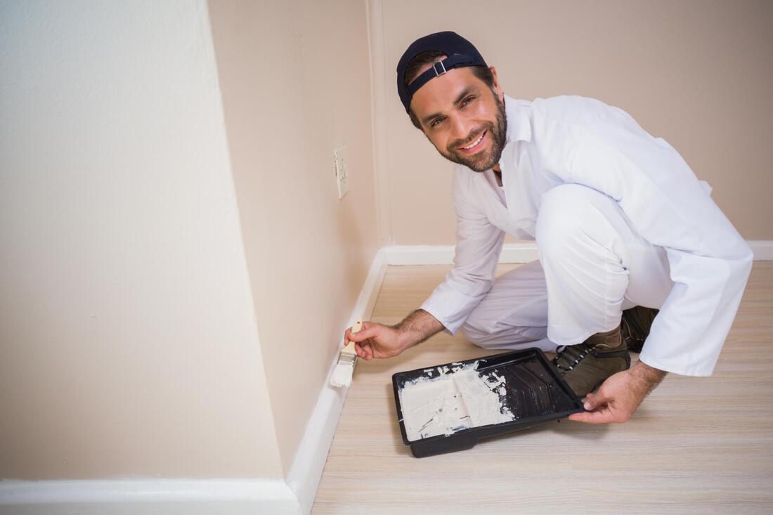 painter paints the baseboard